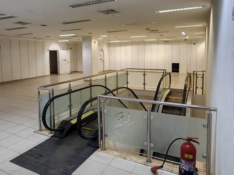 Escada rolante com guarda-corpo de vidro na loja de Pinheiros